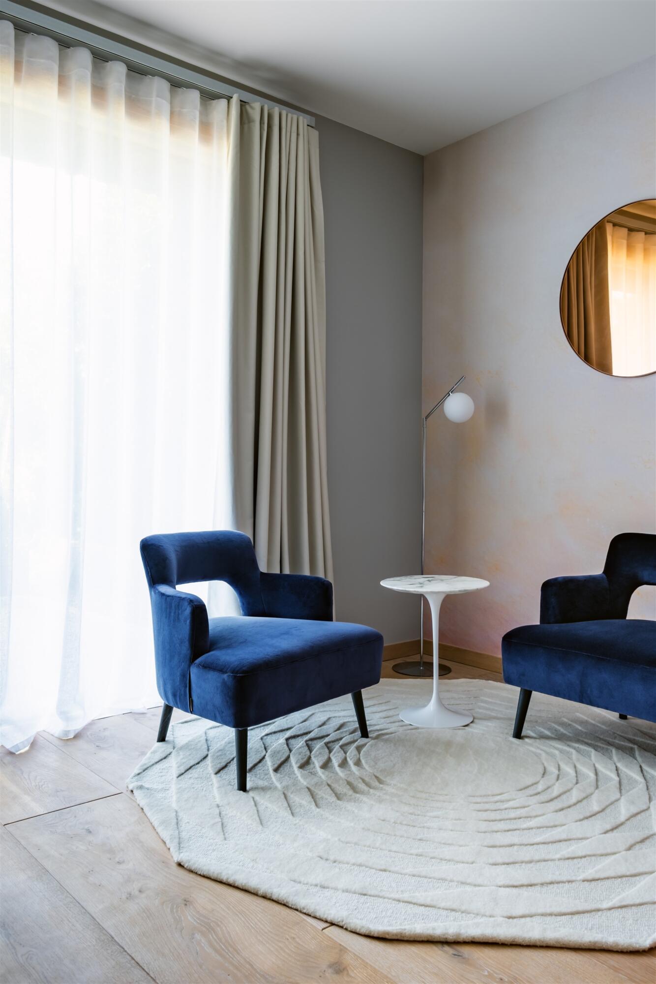 Vue petit salon avec fauteuils velours marine et tapis blanc en laine hexagonal, table en marbre, par Virginie Vaudenay, décoratrice UFDI à Sancerre dans le Cher(18), la Nièvre(58), le Loiret(45), l'Yonne(89) et Sologne(41)