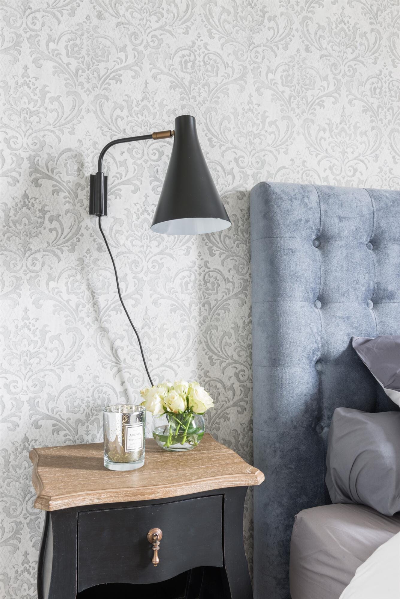 Gros plan chevet et applique acier noir sur fond de papier-peint baroque gris, par Virginie Vaudenay, décoratrice UFDI, à Sancerre dans le Cher(18), la Nièvre(58), le Loiret(45), l'Yonne(89), et Sologne(41)