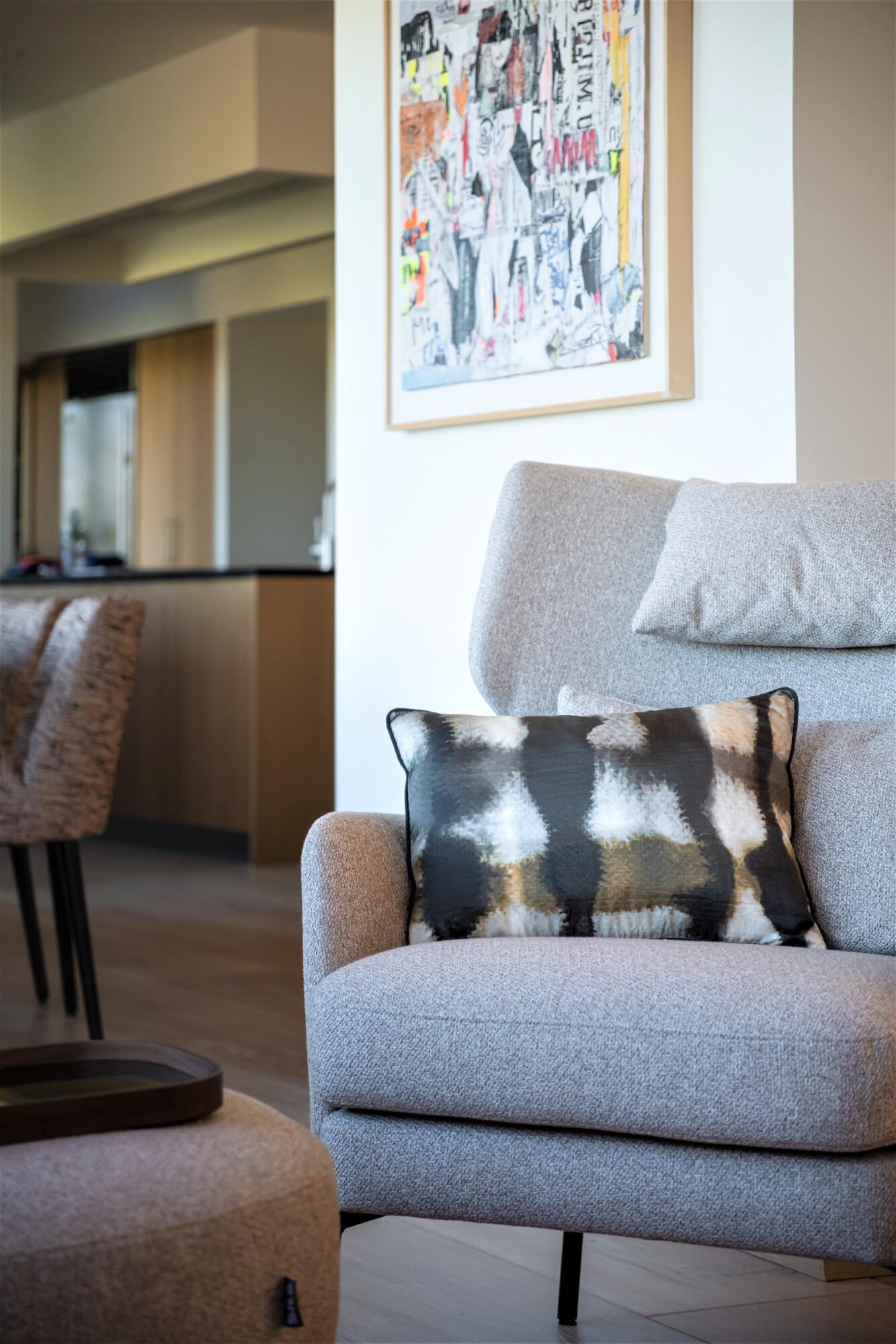 Gros plan fauteuil en flanelle grise et coussin en soie, par Virginie Vaudenay, Décoratrice UFDI à Sancerre, dans le Cher (18), la Nièvre (58) , le Loiret (45) et L’Yonne (89), Sologne(41)